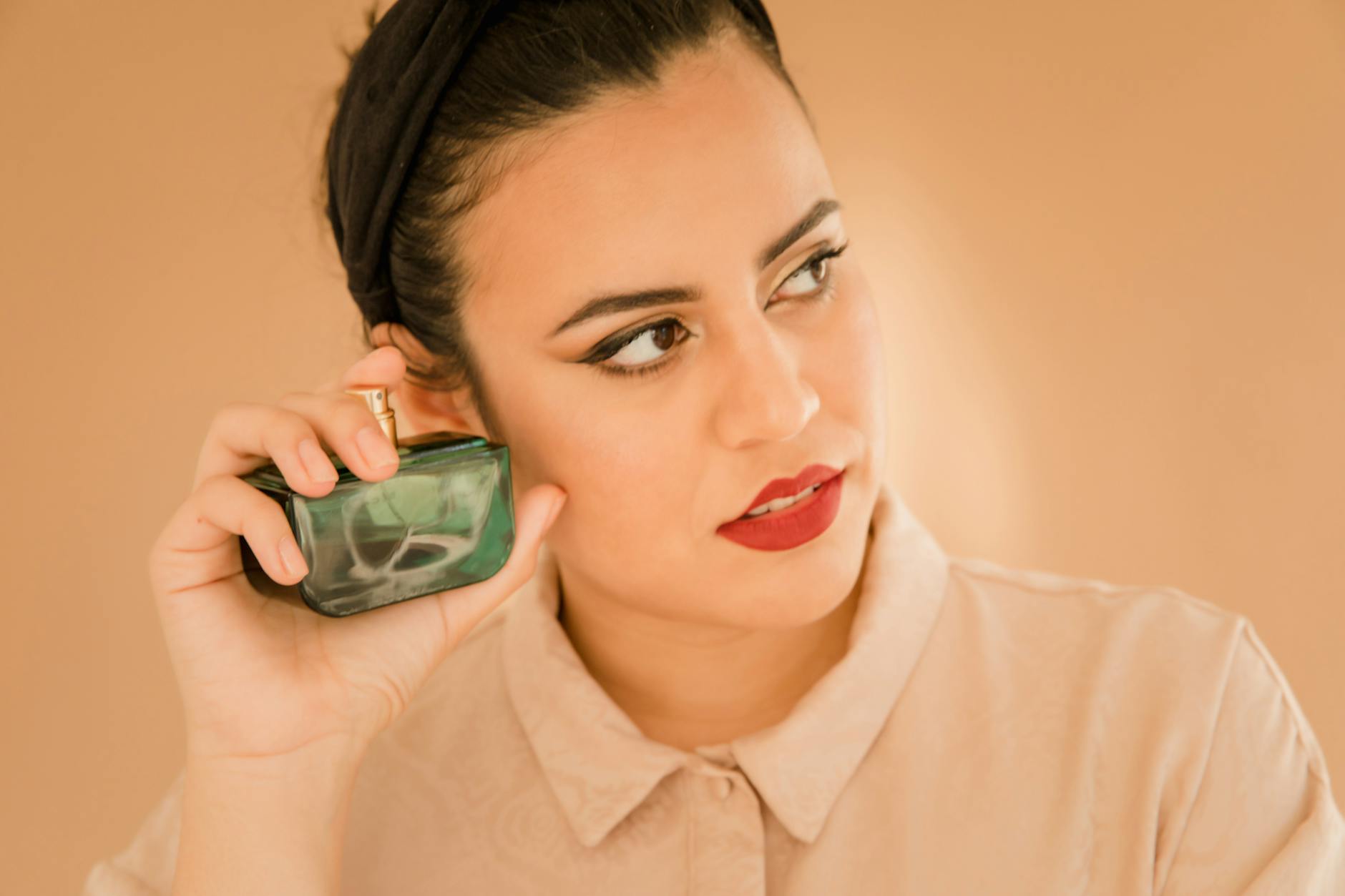 Zamyślona kobieta trzyma flakon perfum podczas wyboru zapachu